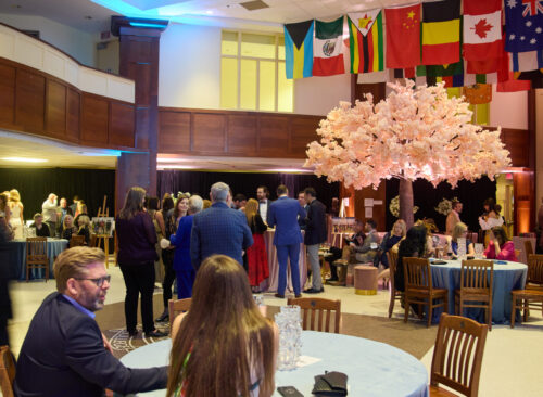 A photo from the Christie Lake Soiree in 2025. The photo is over the event space and shows event goers talking to each other.